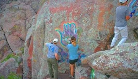 Photo of the Alpine Club of OKC members and FOW volunteers removing graffiti July 2018 at the Wichita Mountains Wildlife Refuge